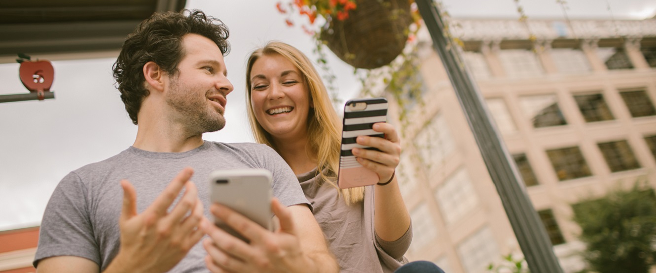 Couple looking at phone outside