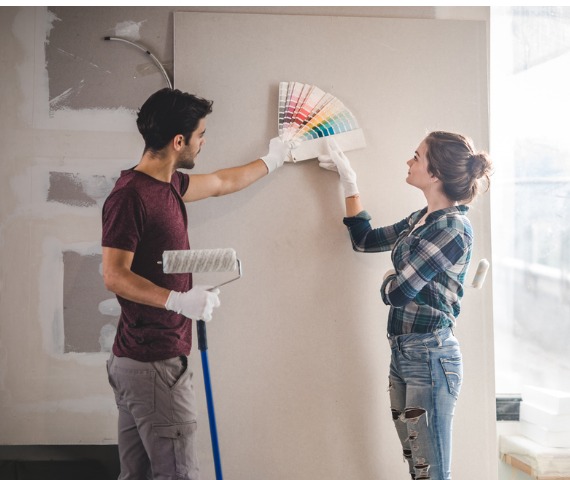 couple choosing paint color for wall